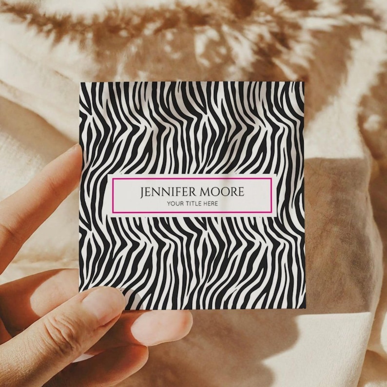 May include: A square business card featuring a black and white zebra print design. The card has a pink border with the name "JENNIFER MOORE" and the text "YOUR TITLE HERE" in white.