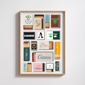 May include: A framed print featuring various vintage matchboxes. The matchboxes display logos and text, including "PETE'S," "CARBONE," "Prince St PIZZA," "little Ruby Cafe," "Catania COASTAL ITALIAN," "Domenico's delicatessen," "Emmy SQUARED," and "Kelliann's BAR & GRILL."