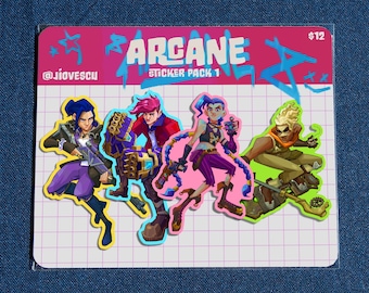 May include: A sticker pack featuring four characters from the animated series Arcane. The characters are Vi, Jinx, Jayce, and Caitlyn. The sticker pack is on a pink and white grid background with the text "ARCANE STICKER PACK 1" and "$12".