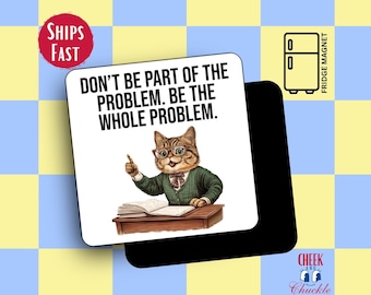 May include: A white fridge magnet with a cartoon cat wearing glasses and a green sweater. The text on the magnet reads "Don't be part of the problem. Be the whole problem."
