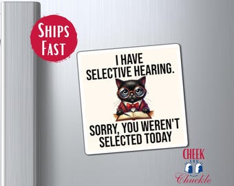 May include: A white square magnet with a black cat wearing glasses and a bow tie. The cat is holding a book and the text reads "I have selective hearing. Sorry, you weren't selected today."