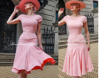 May include: A light pink dress with a matching hat. The dress has a fitted bodice, short sleeves, and a flared skirt. The text "Heartmycloset" is visible. The dress is paired with pink heels.