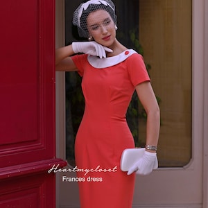 May include: A coral-colored dress with a white collar and short sleeves. The dress is paired with white gloves, a white clutch, and a white headpiece with a veil. The text "Heartmycloset Frances dress" is visible.