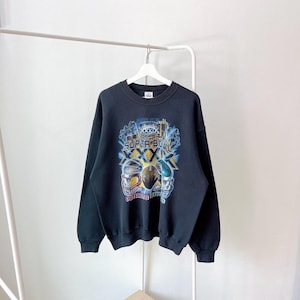 Könnte beinhalten: Schwarzes Sweatshirt mit Rundhalsausschnitt und farbenfroher Grafik des Super Bowl XXIX-Logos, Footballhelmen und den Worten "Super Bowl". Das Sweatshirt hängt an einem weißen Kleiderbügel.