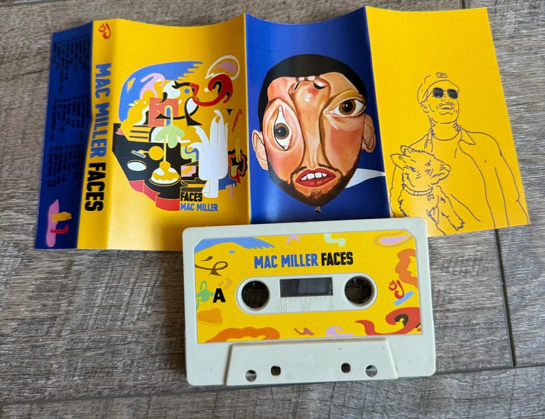 May include: A Mac Miller Faces cassette tape with a white shell and a yellow label featuring abstract shapes and the text Mac Miller Faces. The accompanying J-card insert displays a surreal portrait, colorful abstract illustrations, and a line drawing.