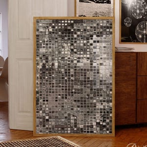 May include: A rectangular wall art piece featuring a grid of small, reflective silver and black square tiles in a light wooden frame. The artwork displays a monochromatic mosaic pattern with varying shades of gray, creating a textured, metallic appearance.