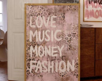 May include: A rectangular wall art print in a wooden frame featuring a pink and brown leopard print background with the white text LOVE MUSIC MONEY FASHION layered over the pattern. The design has a textured appearance with visible brush strokes.