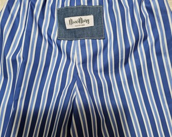 May include: Blue and white striped pajama pants with an elastic waistband. A denim patch with the text "MaxiMary Handmade" is sewn on the back. The pants feature vertical stripes in varying shades of blue and white.
