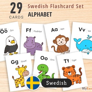 Puede incluir: Un conjunto de 29 tarjetas didácticas del alfabeto sueco. Cada tarjeta presenta una letra, una palabra y una ilustración colorida de un animal. Las tarjetas están dispuestas sobre una superficie de madera clara.