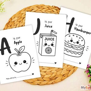 Può includere: Tre pagine da colorare rettangolari bianche con illustrazioni a linee nere. La prima mostra la lettera A con il testo A is for Apple e una mela sorridente. La seconda mostra J is for Juice con un succo. La terza mostra H is for Hamburger.