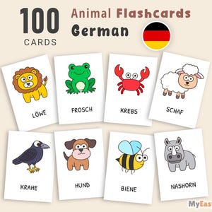 Könnte beinhalten: Ein Set von 100 Tier-Lernkarten auf Deutsch. Jede Karte zeigt eine farbenfrohe Cartoon-Tierillustration mit dem deutschen Wort darunter. Zu den Tieren gehören ein Löwe, ein Frosch, eine Krabbe, ein Schaf, eine Krähe, ein Hund, eine Biene und ein Nilpferd.