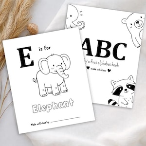 Può includere: Due libri di alfabeto per bambini bianchi. Un libro presenta la lettera "E" con un'illustrazione di elefante e la parola "Elephant". L'altro libro dice "ABC" e "Baby's first alphabet book". Entrambi i libri hanno disegni a tratto nero.