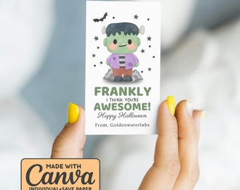 Op de afbeelding: Een witte Halloween-kaart met een cartoon Frankenstein-monster en de tekst "FRANKLY I THINK YOU'RE AWESOME! Happy Halloween". De kaart wordt vastgehouden door een persoon met gele nagellak.
