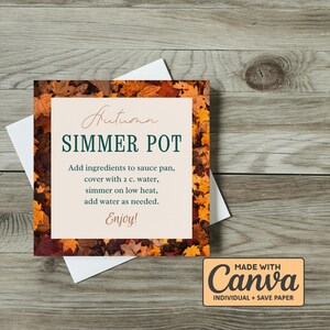 May include: A square card with an autumn theme, featuring text that reads "Autumn Simmer Pot." The card is surrounded by a border of fall leaves in shades of orange, brown, and yellow. Instructions are included.