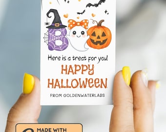 May include: A Halloween-themed card featuring a purple 'BOO' with a witch hat, a ghost with a bow, and an orange jack-o'-lantern. The card includes the text "Here is a treat for you! HAPPY HALLOWEEN" and "MADE WITH Canva".