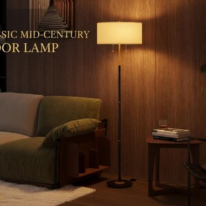 Pu&ograve; includere: Una classica lampada da terra di met&agrave; secolo con paralume rettangolare. La lampada ha un palo nero con dettagli dorati e una base rotonda. Il testo "CLASSIC MID-CENTURY FLOOR LAMP" &egrave; visibile.