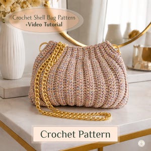 May include: A crocheted shell bag in pastel colors with a gold chain strap. The bag has a ribbed texture and is displayed on a marble surface. Text on the image reads "Crochet Shell Bag Pattern + Video Tutorial" and "Crochet Pattern".