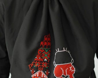 May include: Black drawstring bag with a red and green embroidered design of a person and a stylized map.