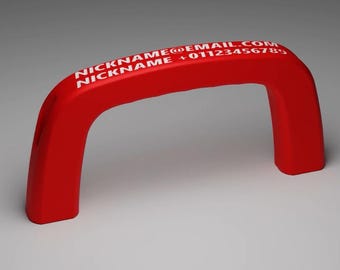 May include: A bright red, arched handle featuring white printed text on the top surface. The text reads NICKNAME@EMAIL.COM and NICKNAME +01123456789. The handle has a smooth, solid construction with two vertical legs and a curved top section.