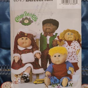 May include: A Butterick pattern envelope featuring Cabbage Patch Kids dolls. The dolls are dressed in various outfits, including a plaid dress, a green vest, and a red shirt. The envelope has the text "4045 Butterick" and "Cabbage Patch Kids".