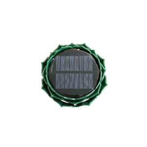 Op de afbeelding: Een bovenaanzicht van een zonne-aangedreven tuinlamp. De lamp heeft een donkergroen zonnepaneel omgeven door een groene, bloemblad-vormige lijst. De lamp is ontworpen om op een bloem te lijken.