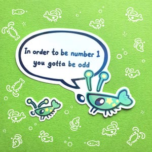May include: Two light green cartoon shrimp stickers on a textured green background with white line art of shrimp. The larger shrimp has a white speech bubble with dark blue text that reads, In order to be number 1 you gotta be odd.