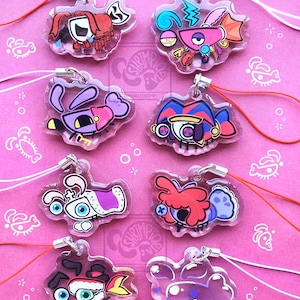 May include: Eight clear acrylic charms featuring colourful, stylised cartoon creatures with various expressions and accessories. Each charm is attached to a thin, flexible cord in either red or white, designed for hanging as decorative accessories.
