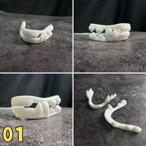 Puede incluir: Cuatro imágenes de modelos de dientes y mandíbulas blancos impresos en 3D. Los modelos incluyen un juego completo de dientes superiores e inferiores, y piezas individuales de mandíbula. Los modelos se muestran sobre un fondo gris oscuro.