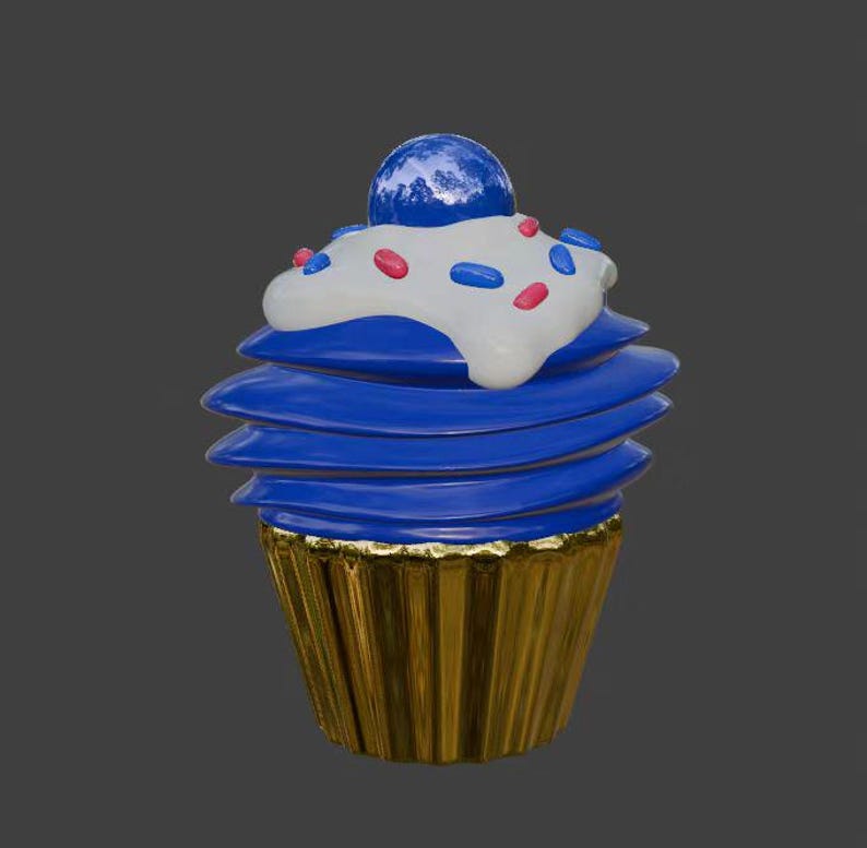 Puede incluir: Un cupcake azul y blanco con un forro de cupcake dorado. El cupcake est&aacute; cubierto con glaseado blanco y chispas azules y rosas.