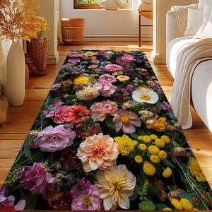 Op de afbeelding: Een kleurrijk bloemenloper met een donkere achtergrond. De loper heeft een verscheidenheid aan bloemen in tinten roze, rood, geel en wit. De bloemen zijn in een willekeurig patroon gerangschikt, wat een levendig en opvallend ontwerp creëert.