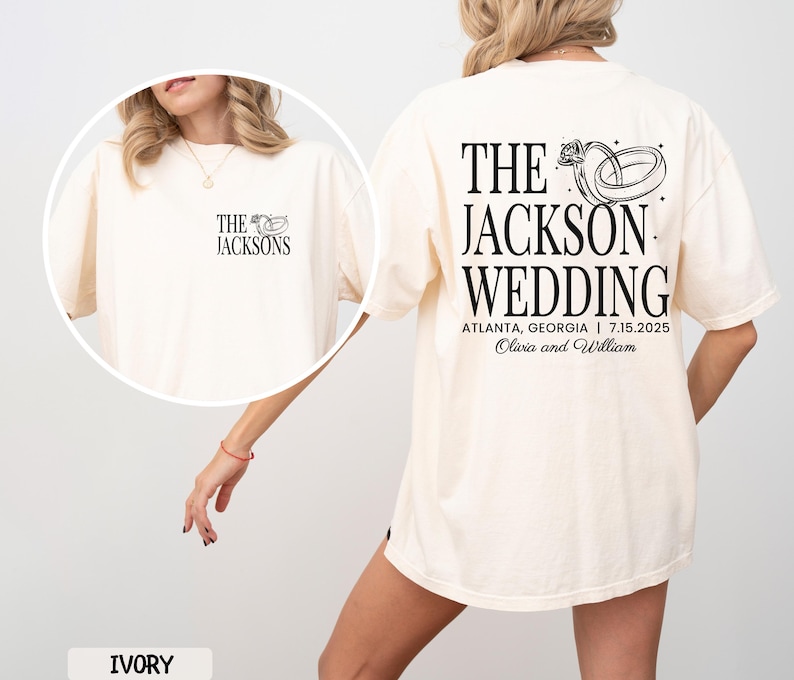 May include: Ivory t-shirt featuring black text and a wedding ring graphic. The front displays "THE JACKSONS" with a ring graphic. The back reads "THE JACKSON WEDDING" with the wedding date and location.