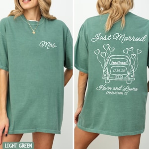 May include: Light green t-shirts with white text. One shirt says "Mrs." on the front. The other shirt says "Just Married" with a car graphic, date, and names on the back. The shirts are a relaxed fit.