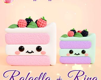May include: Two miniature cake slices made of polymer clay, decorated with pink, white, green, and purple frosting. The cakes have cute faces and are topped with blackberries and raspberries. The text "Puff Puff Pastries" and "Raffaella + Rina" is visible in the image.