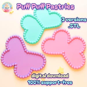 Op de afbeelding: Drie kleurrijke, vlindervormige bakvormen in roze, paars en blauwgroen, elk met een kralenrand. De afbeelding bevat de tekst "Puff Puff Pastries", "3 versions .STL", "digitale download" en "100% support-free".