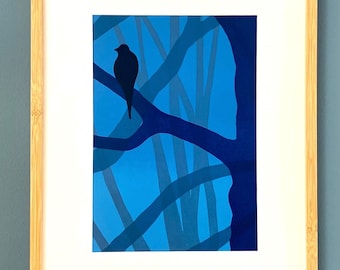 May include: A framed art print featuring a silhouette of a bird perched on a branch. The artwork uses shades of blue to depict a stylized tree against a lighter blue background. The frame is made of light-colored wood.