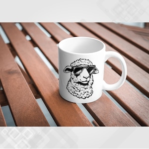 May include: White ceramic mug with a black and white illustration of a sheep wearing sunglasses. The sheep is looking to the right.