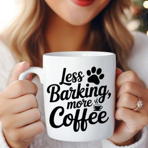 May include: White ceramic coffee mug with the text "Less Barking, more Coffee" in black script and a paw print graphic. The mug also features a small coffee cup graphic. A perfect gift for dog lovers.