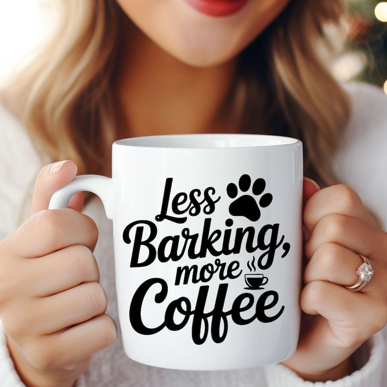 May include: White ceramic coffee mug with the text "Less Barking, more Coffee" in black script and a paw print graphic. The mug also features a small coffee cup graphic. A perfect gift for dog lovers.