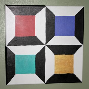 May include: A square canvas painting with a geometric design. The painting is divided into four sections, each with a different color: red, blue, teal, and gold. The sections are separated by black lines.