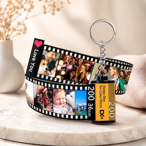 May include: A custom film roll keyring featuring a strip of printed photographs. The canister is yellow and black with text reading 35mm Film for Color Prints 200 36 EXP. The film strip includes a red heart and the text Love You.