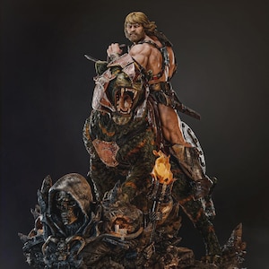 May include: A detailed statue of a muscular warrior riding a large, armoured beast. The warrior, with long blonde hair, holds a sword. The beast has green and brown fur and a snarling expression. The base features a skull and other sculpted elements.