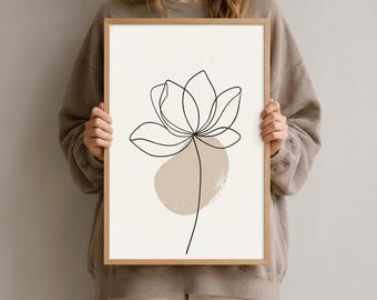 Könnte beinhalten: Ein rechteckiger gerahmter Kunstdruck mit einer schwarzen, durchgehenden Linienzeichnung einer Blume, die auf einem cremefarbenen Hintergrund zentriert ist. Hinter dem Blumenstiel befindet sich eine abstrakte, beige, organische Form.