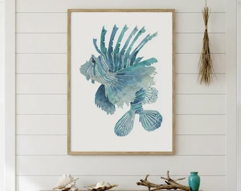 May include: A framed watercolor print of a lionfish in shades of blue and teal. The artwork features a detailed depiction of the fish with flowing fins and spiky dorsal spines. The print is displayed on a white wall, adding a coastal theme.