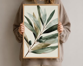 Könnte beinhalten: Ein rechteckiger gerahmter Wandkunstdruck mit einer Aquarellillustration eines Olivenzweigs mit länglichen grünen Blättern und kleinen dunkelgrünen Oliven vor einem hellcremefarbenen Hintergrund, eingefasst in einen schlichten hellen Holzrahmen.