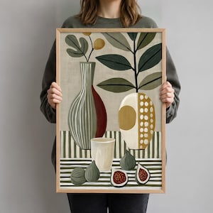Op de afbeelding: Een ingelijste kunstdruk met een stilleven van twee vazen, een klein kopje en vier vijgen. De hoge vaas heeft groene strepen en een rode zijkant, terwijl de ronde vaas een gouden cirkel en witte stippen bevat. De achtergrond is beige.