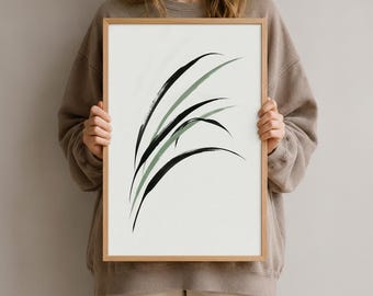 Könnte beinhalten: Ein rechteckiges gerahmtes Wandbild mit weißem Hintergrund und einer minimalistischen abstrakten Illustration aus langen, geschwungenen grasartigen Halmen in Schwarz und gedämpftem Salbeigrün, eingefasst in einen hellen Holzrahmen.