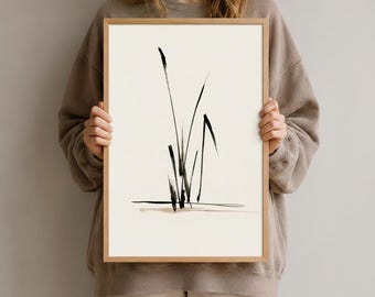Könnte beinhalten: Ein gerahmter vertikaler Wandkunstdruck mit einer minimalistischen schwarzen Tuschepinsel-Illustration von hohem Gras oder Schilf auf einem cremeweißen Hintergrund. Das Kunstwerk befindet sich in einem hellen Holzrahmen mit schlichtem Rand.