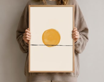 Könnte beinhalten: Ein rechteckiges gerahmtes Wandbild mit einem soliden, kreisförmigen senfgelben Sonnenmotiv, das über einer einzelnen, dünnen, horizontalen schwarzen Linie auf einem hellen cremefarbenen Hintergrund in einem hellen Holzrahmen platziert ist.
