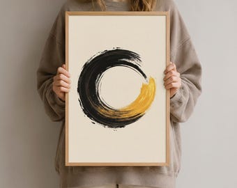 Könnte beinhalten: Ein gerahmter Wandkunstdruck mit einem kreisförmigen Pinselstrich-Design auf cremefarbenem Hintergrund. Der Kreis besteht aus dicken, strukturierten schwarzen Farbstrichen, die in einen leuchtend goldenen Bereich unten rechts übergehen.