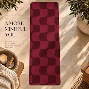 May include: A rectangular yoga mat featuring a repeating geometric pattern of interlocking wavy shapes in two shades of deep red. The text on the left reads POPANDPRINTSTUDIO, A MORE MINDFUL YOU, and PREMIUM YOGA MAT FOR EVERYDAY RITUALS.